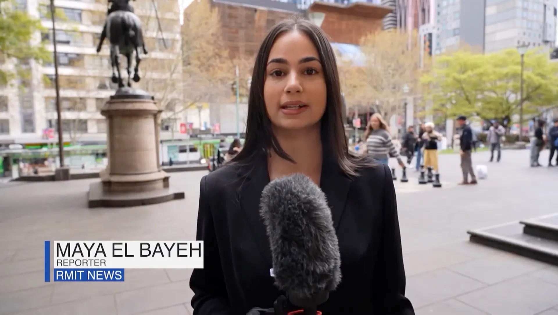 Maya El Bayeh reporting to camera on a Melbourne street, with an on-screen caption reading Reporter, RMIT News.